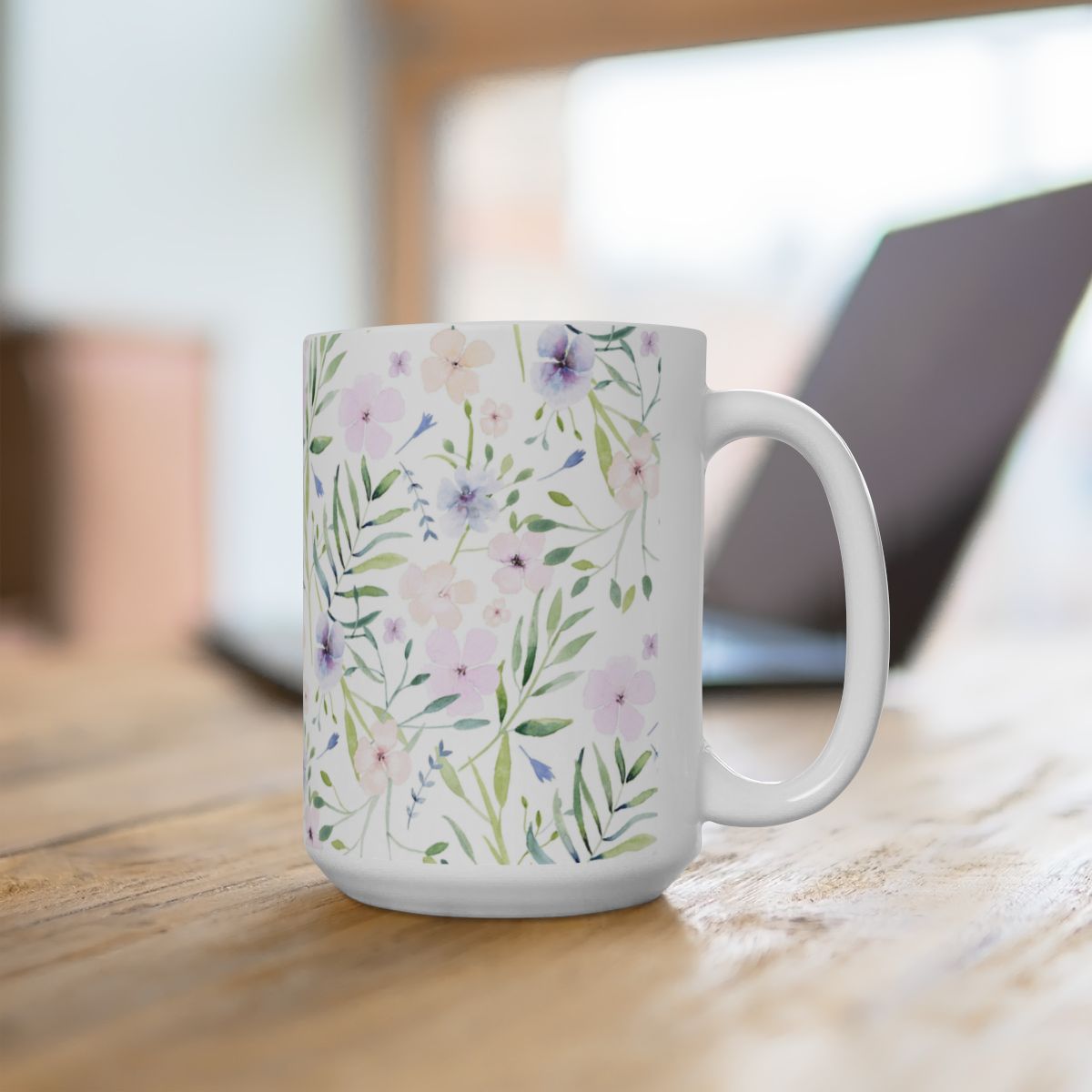 15oz watercolor floral retirement mug on a wooden desk next to a laptop